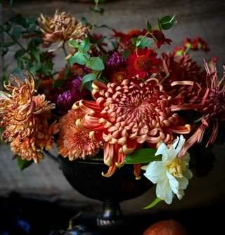 Floral arrangement featuring deep bronze and gold chrysanthemums