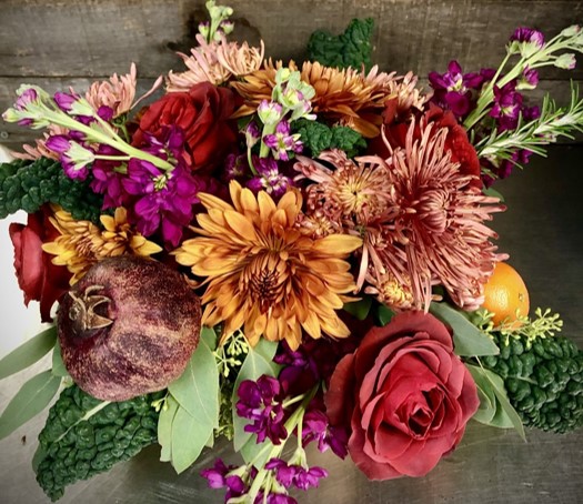 Floral centerpiece featuring kale, stock, mums and roses