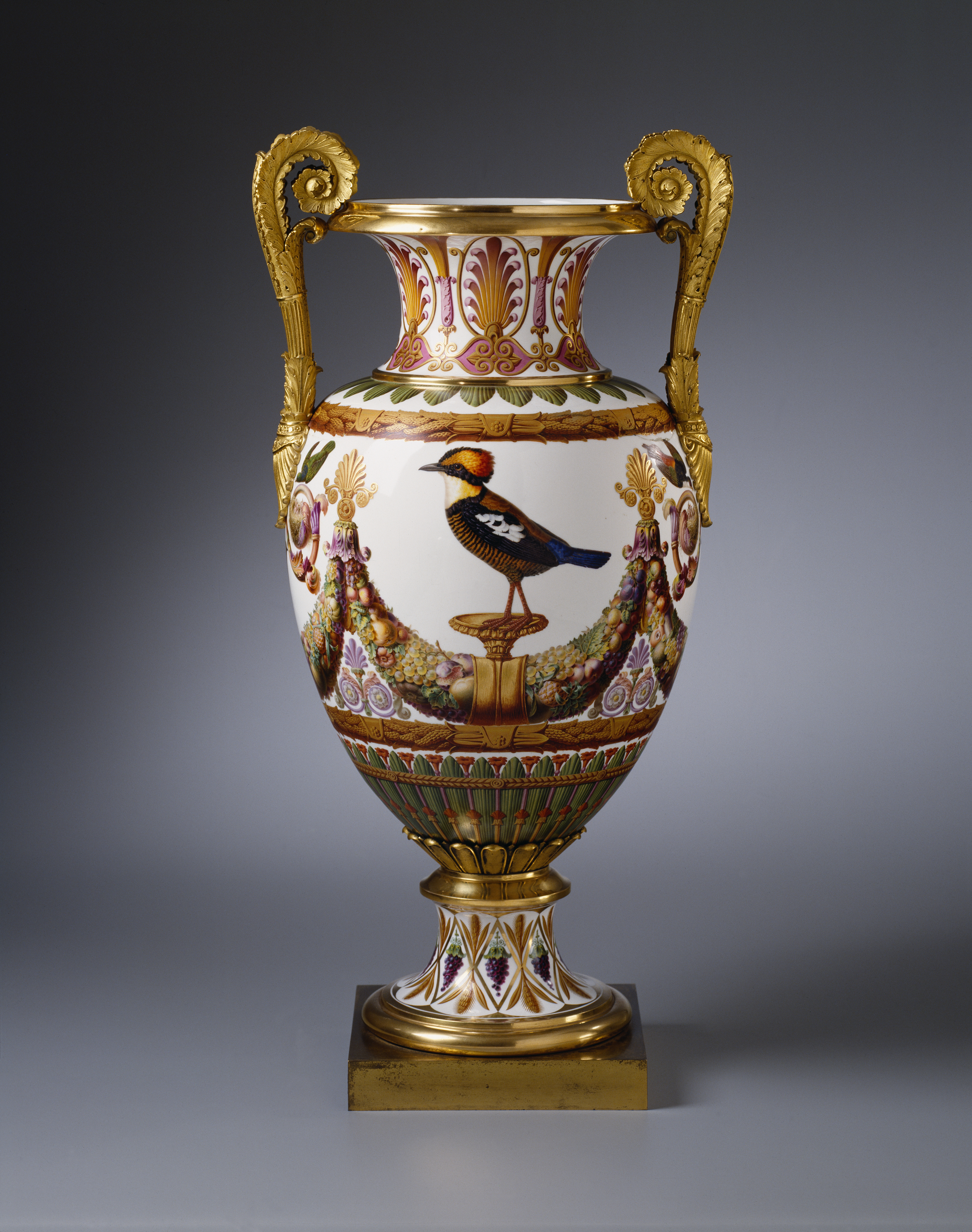 Image of a porcelain vase created by Madame Knip. It features a bird surrounded by purple and gold decorative features.