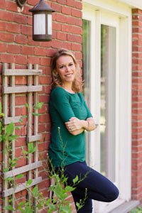 Allison Pataki leaning against a red brick wall