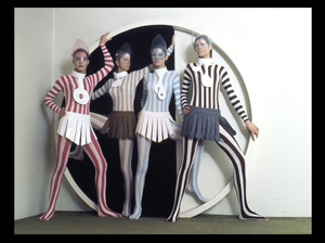 Four models wearing vertically striped, head-to-toe outfits designed by Pierre Cardin