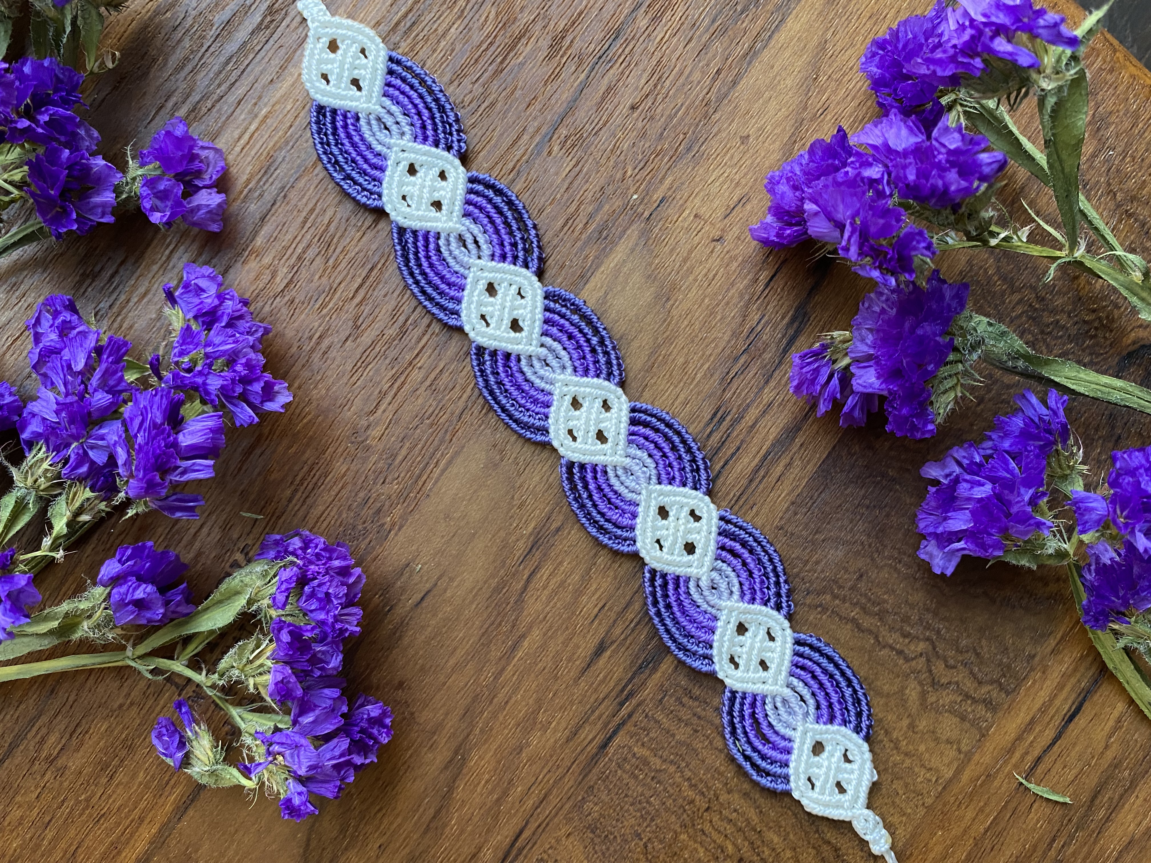 Purple woven bracelet on a wood table