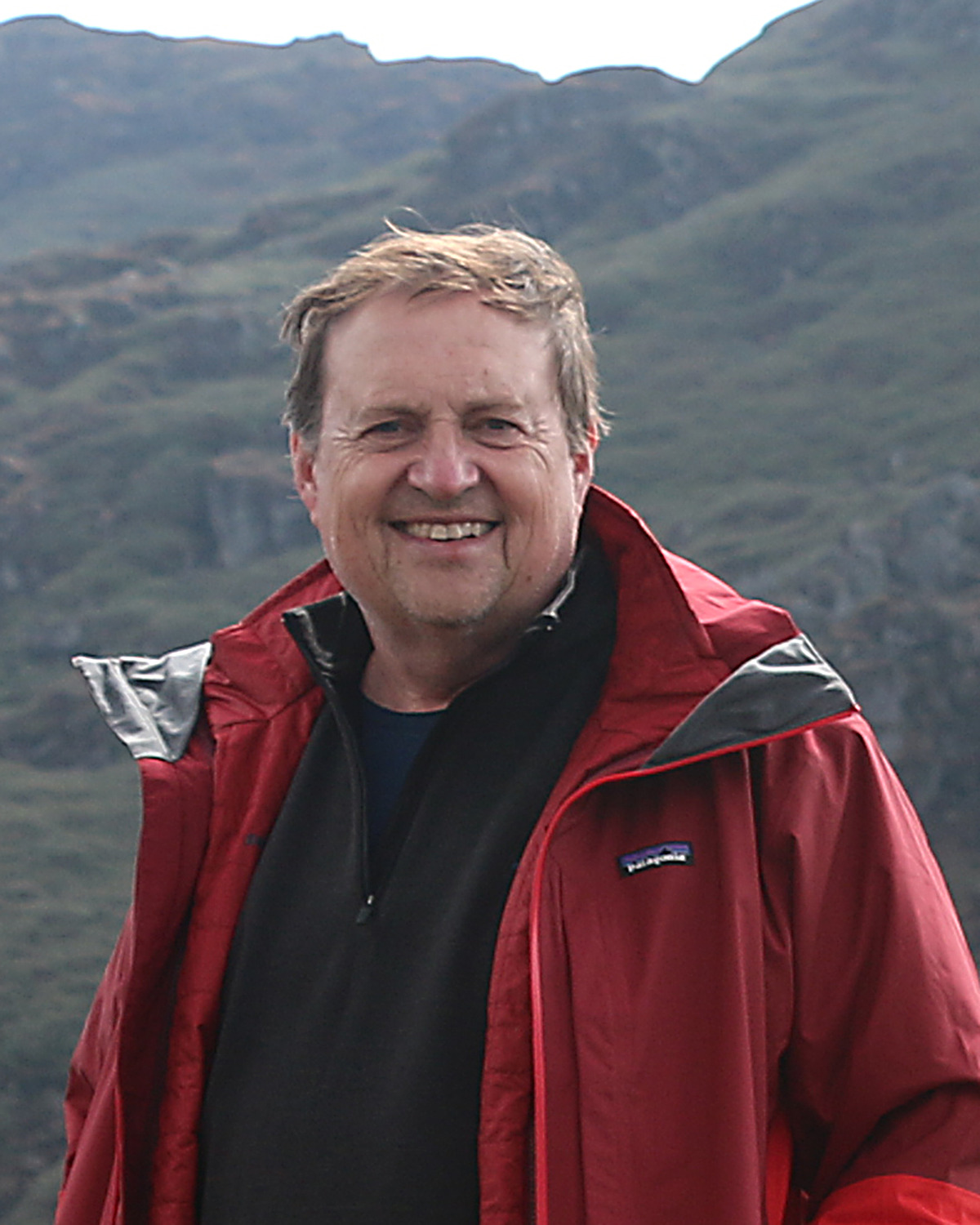 Image of Douglas Hamilton standing in front of a mountain range.