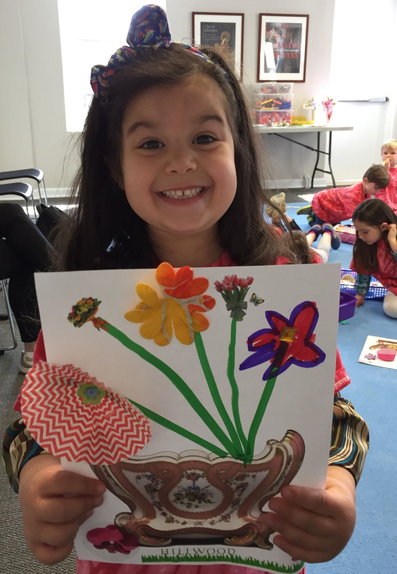preschooler holding up completed art project