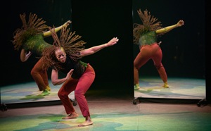 Dancer crouching, caught in motion with one arm in the air, reflected by two mirrors in the background