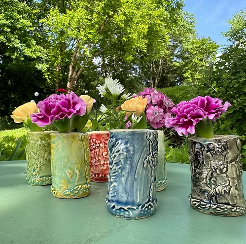 Ceramic vases on a table, each filled with flowers