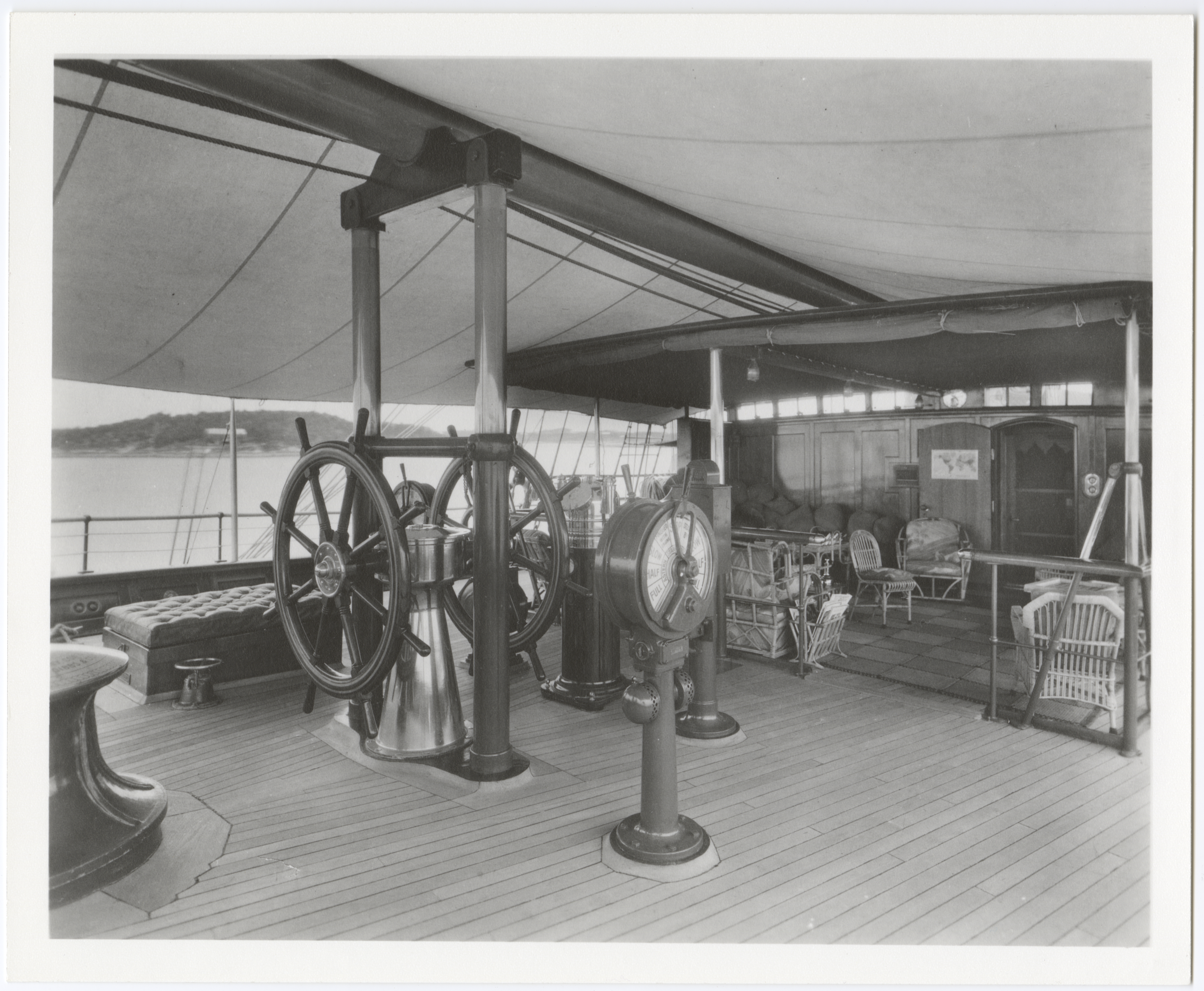 Image of the helm of the Sea Cloud, featuring steering wheel and other directional gear.