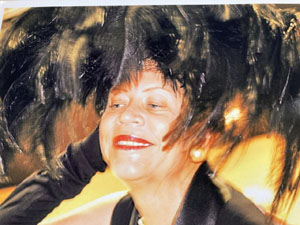 Photo of Donna Limerick wearing a hat adorned with black feathers