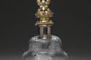 LARGE GLASS BOTTLE WITH STOPPER FROM A DRESSING TABLE SET (ONE OF TWO)