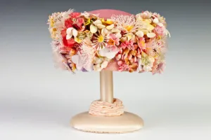 PINK BUBBLE TOQUE COVERED IN ARTIFICIAL FLOWERS