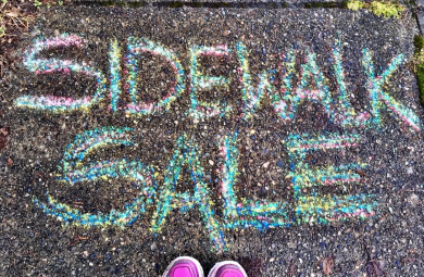 Sidewalk Sale written in chalk on a sidewalk