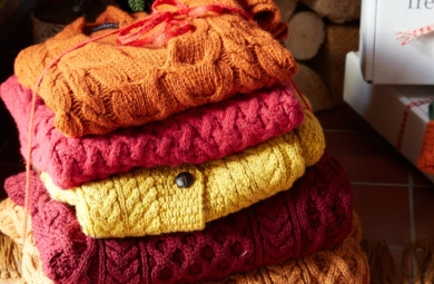 Stack of orange, red, and yellow knitwear