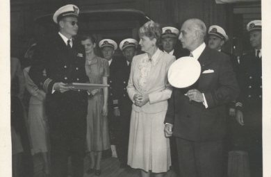 Black and white photo of Captain Skinner presenting a certificate to Marjorie Post and her husband, Joseph E. Davies.