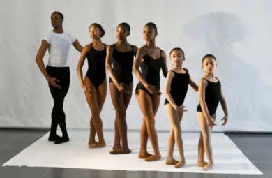 Image of dancers of varying ages posed in a line.