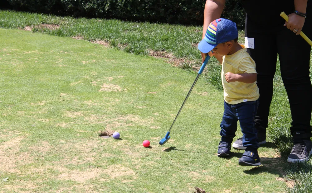 Boy putting on putting green