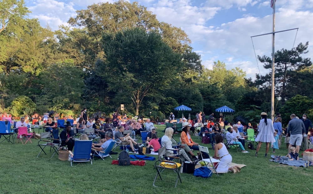 Crowd at evening concert on Hillwood's Lunar Lawn, set among luscious trees