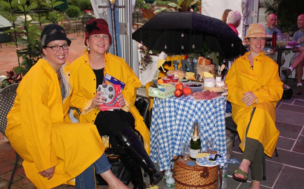 Group dressed in yellow rain slickers with an umbrella to celebrate the film Singing In the Rain