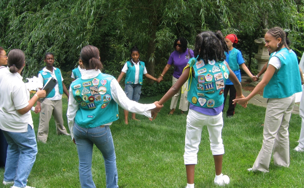 Girl Scouts holding hands in a circle in Hillwood's gardens