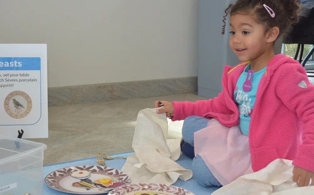 Young girl wearing pink sweatshirt and tutu designing their own plate