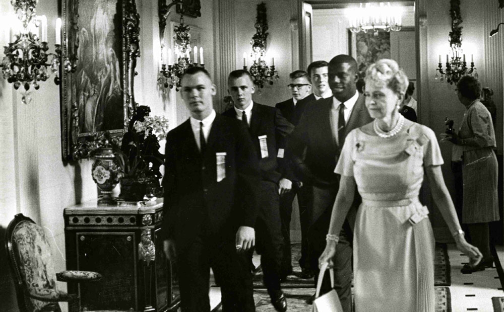 Marjorie Post leading students through the entry hall, 1963