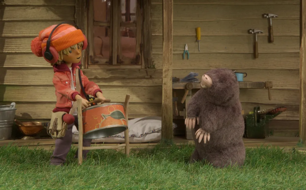 animated still of a youth playing steel drums and a mole dancing