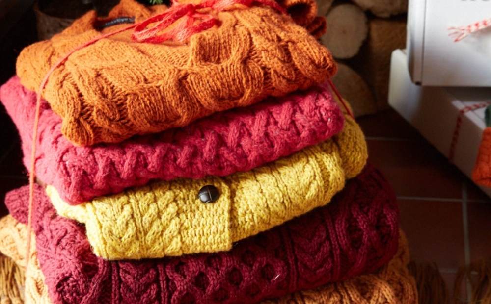 Stack of orange, red, and yellow knitwear