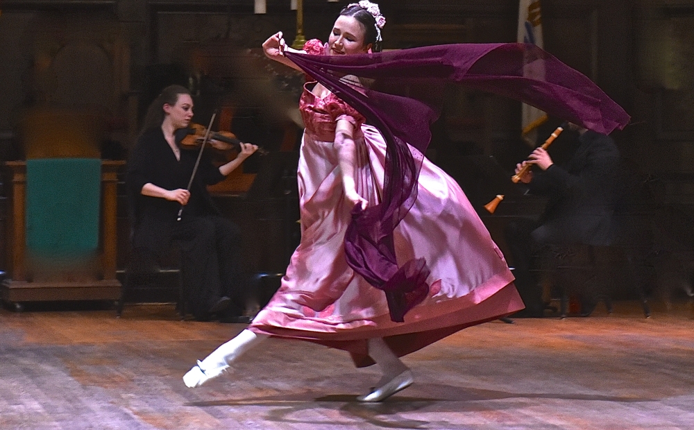 Dancer in historic costume with a purple scarf.