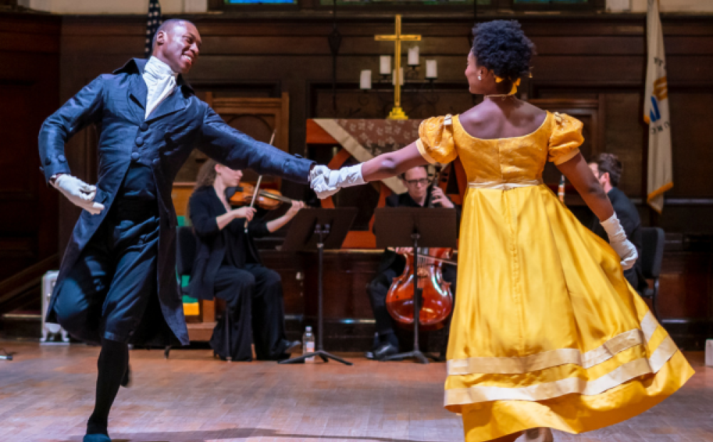 Image of two dancers, mid performance. 