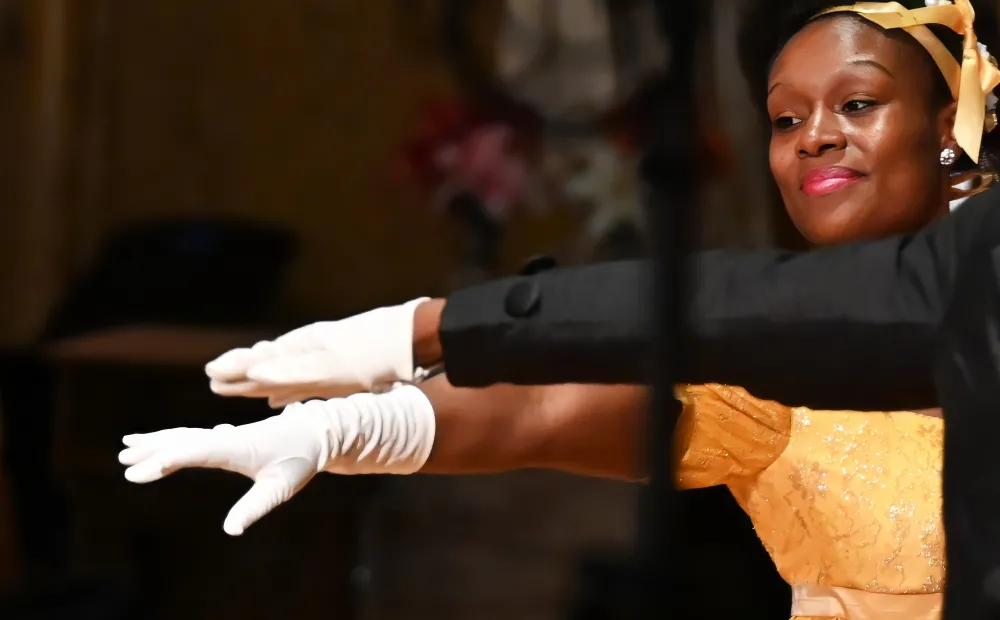 Image of two dancers holding their hands over each other's.