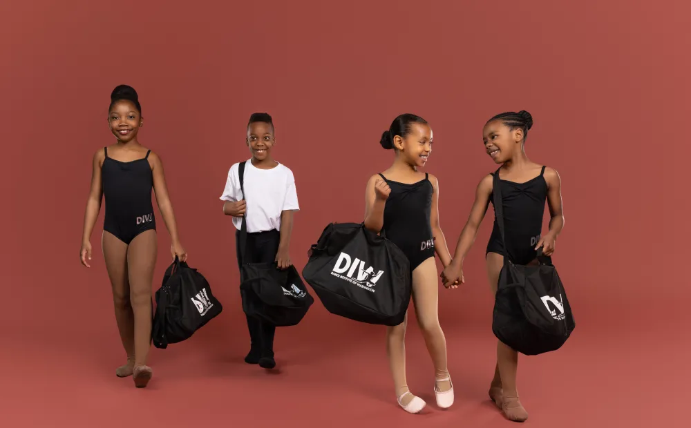 Image of young dancers with their rehearsal bags. 