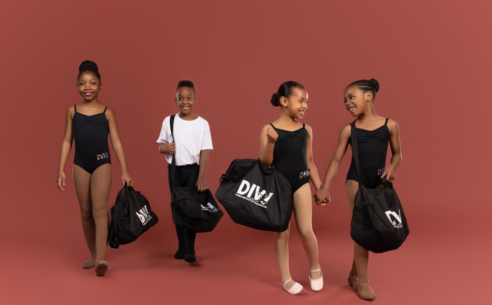 Image of young dancers with their rehearsal bags. 
