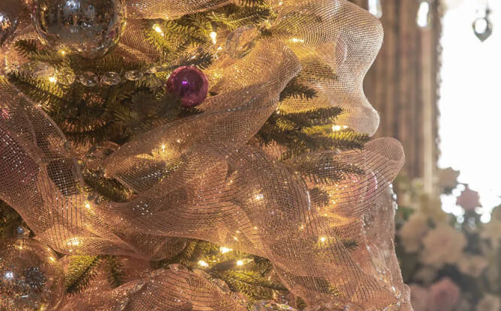 Close image of holiday tree in the mansion with tulle decoration and pink ornaments