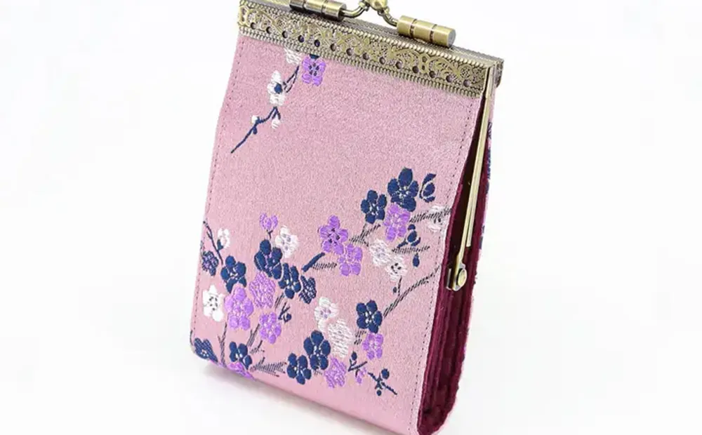 Pink coin purse decorated with embroidered flowers